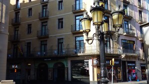 Un immeuble à plusieurs étages, doté d’une façade jaune, de nombreux balcons et d’un lampadaire au premier plan.