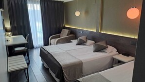 Une chambre d’hôtel moderne avec un grand lit, des tables de chevet, un bureau et une chaise.