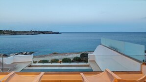 En balkon med udsigt til havet og en klippefyldt kystlinje.