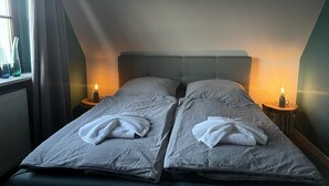 Ein Doppelbett mit zwei Kissen, einem Kopfteil und Nachttischlampen.