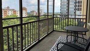 Un balcón con vistas a un paisaje urbano, que incluye un hotel y otros edificios.