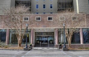 Un edificio con un cartel que dice 'PEACHTREE TOWERS' y un conjunto de escaleras que conducen a la entrada.