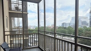 A balcony with a view of a cityscape, a chair, and a railing. - Condo in the Heart Atlanta w/ Private Balcony (Atlanta)
