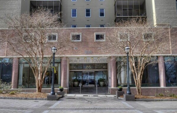 A building with a sign reading 'PEACHTREE TOWERS' and a set of stairs leading to the entrance. - Condo in the Heart Atlanta w/ Private Balcony (Atlanta)