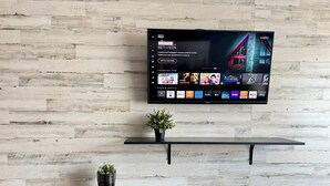 Televisor de pantalla plana montado en una pared con diseño de tablones de madera.
