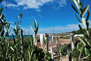 A covered outdoor seating area with a view of the sea. - The Antiche Pajare (Marina di Felloniche)