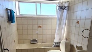 A small bathroom with two toilets, a bathtub, and a window. - Large Student Penthouse in Nicosia · 4 Beds + Master En-Suite · Walk to Center (Nicosia)