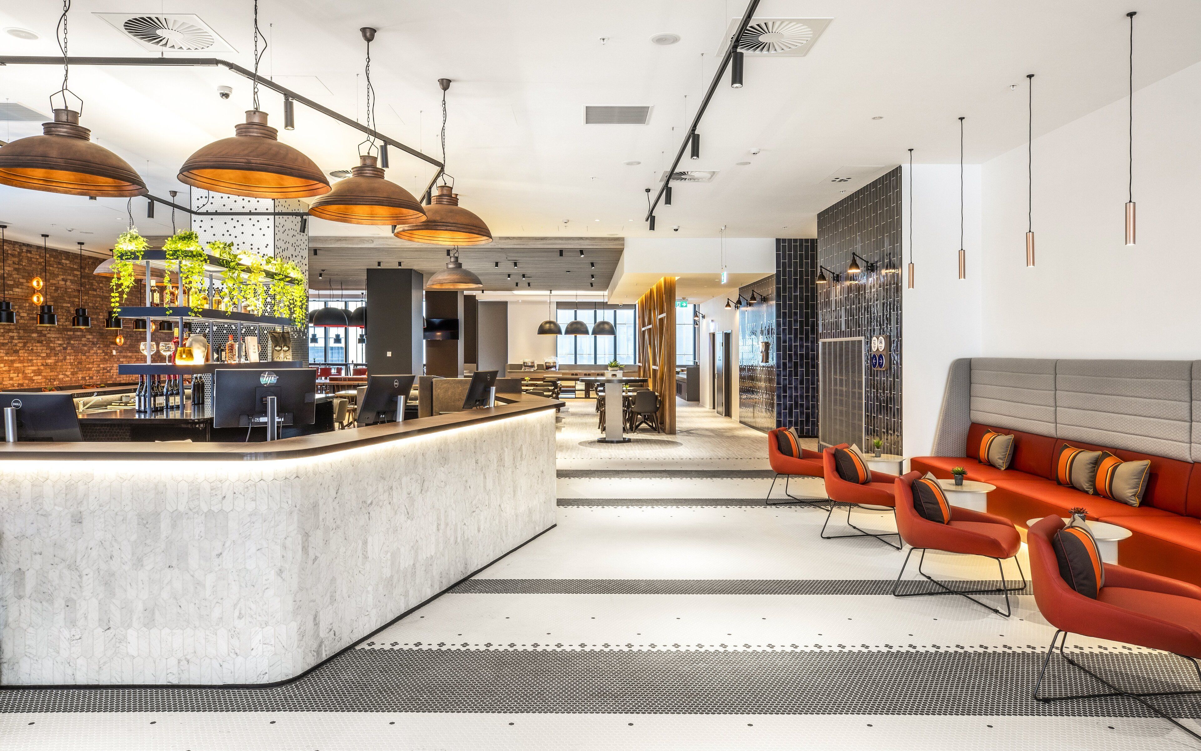 Uma área de bar moderna com balcão, assentos e iluminação pendente.