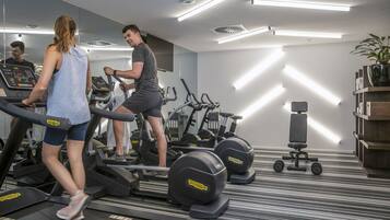 A gym with treadmills, exercise bikes, and weight machines.