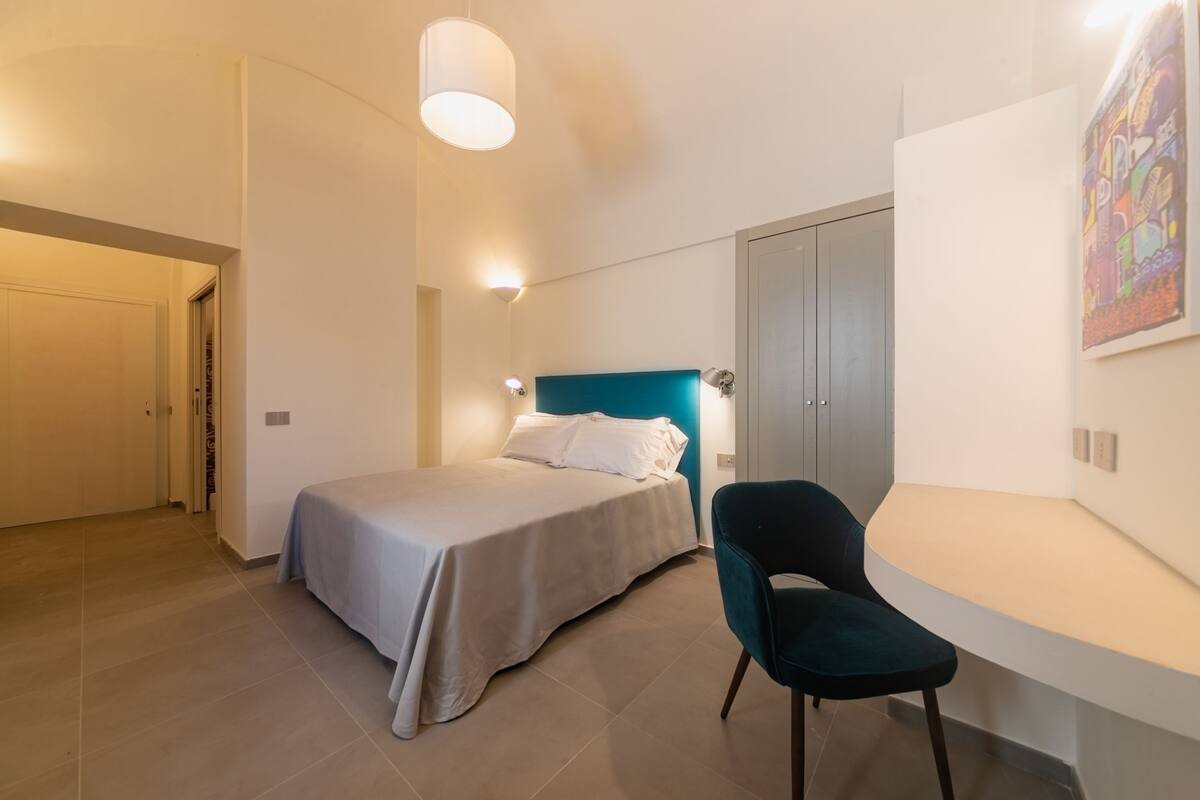 Un dormitorio con cama, escritorio, silla y armario.