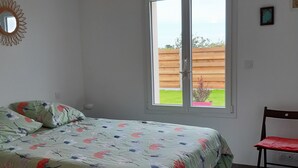 Une chambre à coucher avec un lit, une chaise, une fenêtre et un luminaire au plafond.