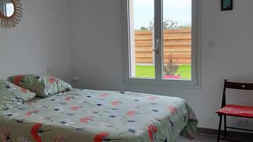 Une chambre à coucher avec un lit, une chaise, une fenêtre et un luminaire au plafond.