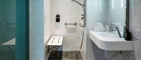 A modern bathroom with a shower, a sink, and a small table.