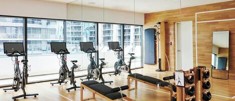 A gym with exercise bikes, benches, and a shoe rack.
