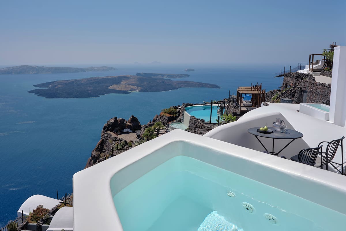 A luxurious outdoor jacuzzi with a clear view of the sea and islands.