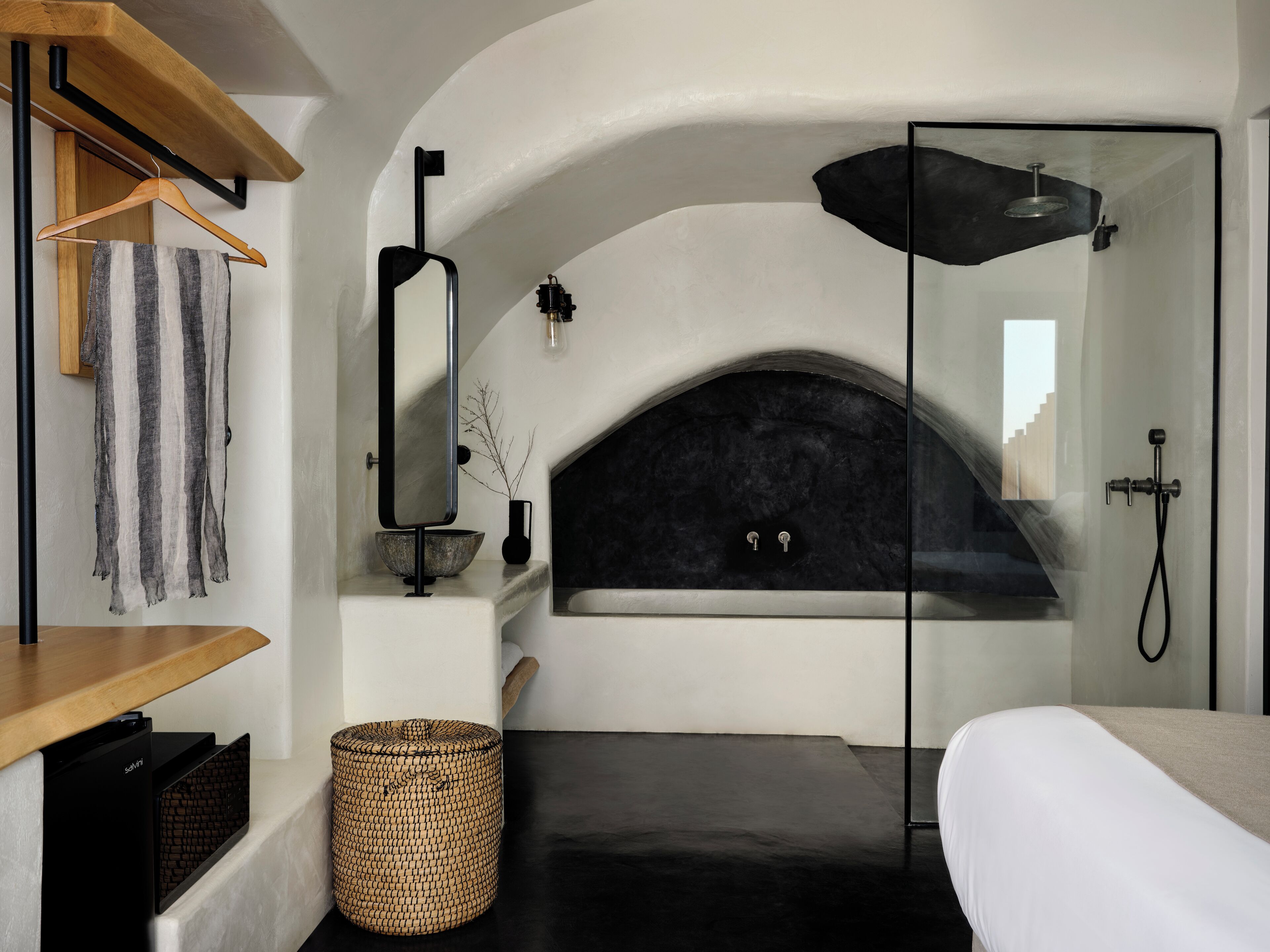 A modern bathroom with a freestanding bathtub, a glass shower enclosure, and a minimalist design.