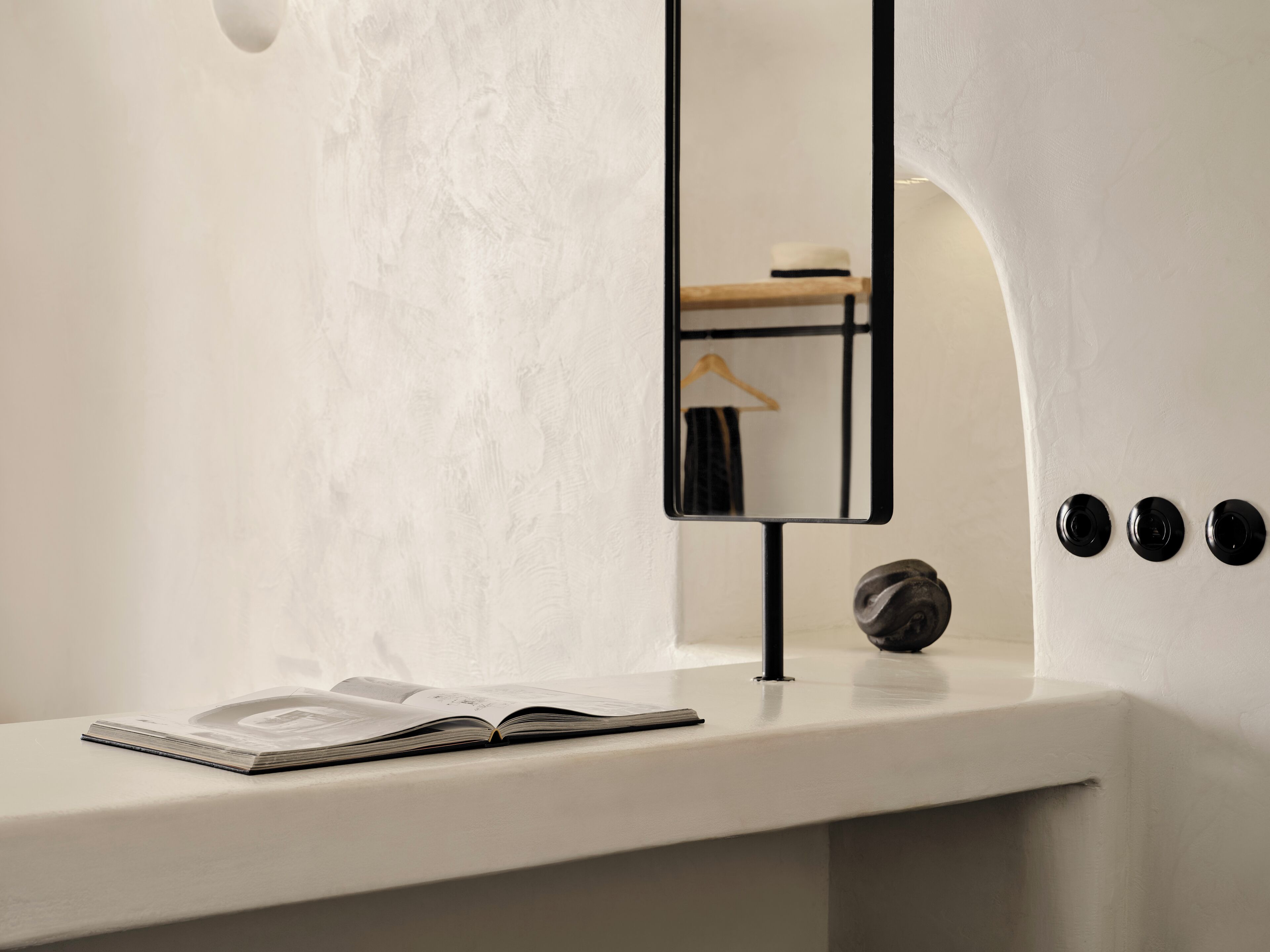 Une salle de bain minimaliste avec un meuble-lavabo blanc, un miroir et un porte-serviettes.
