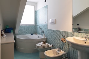 A bathroom with a bathtub, toilet, bidet, and sink. - notaMi - Oskar Home - Tre Ponti (Milan)