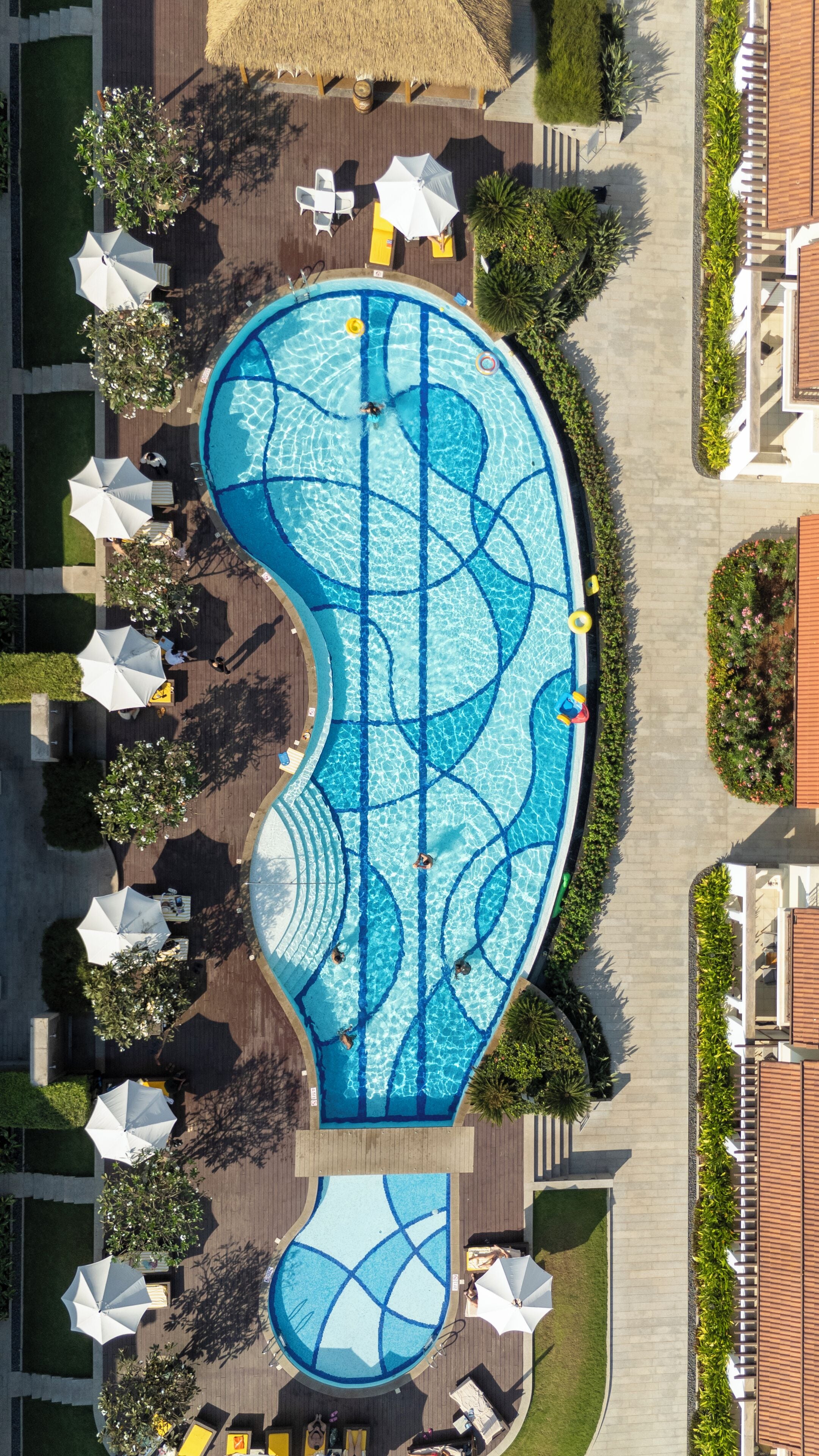Een buitenzwembad, parasols bij het zwembad en ligstoelen