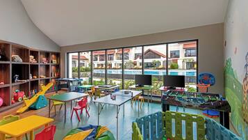 A children's play area with tables, chairs, and a ball pit.