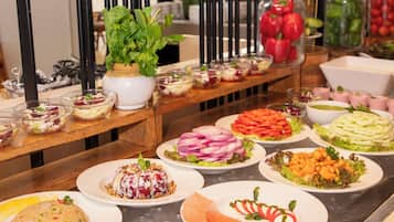 Un buffet proposant une variété de plats, notamment des salades, des légumes et différents types d’aliments.