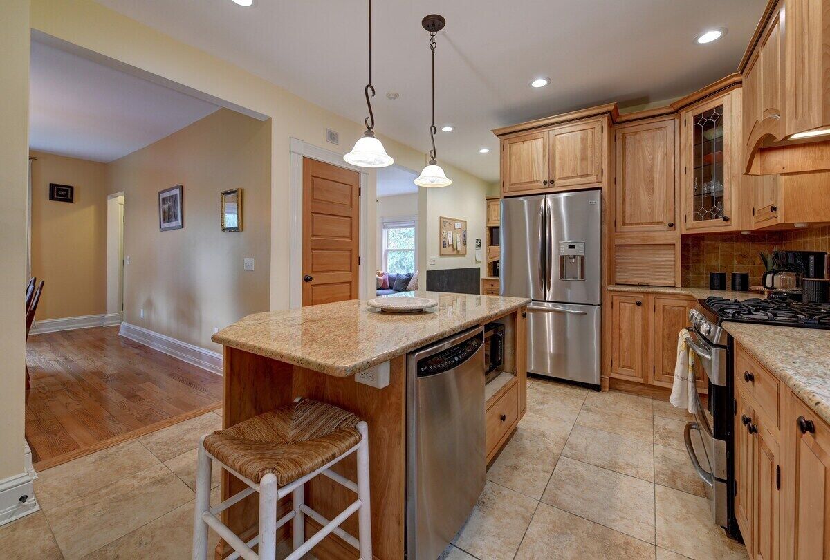 A kitchen with wooden cabinets, stainless steel appliances, and a granite countertop.