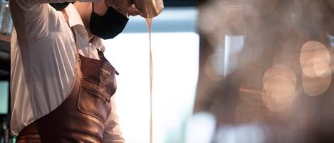 A person pouring a liquid from a shaker bottle.