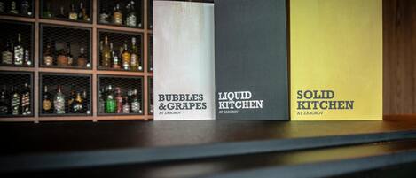 Tres cajas etiquetadas en un estante, cada una con un nombre diferente: 'Bubbles & Grapes', 'Liquid Kitchen' y 'Solid Kitchen'.