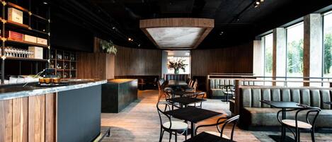A modern bar area with a counter, seating, and a view of the outdoors.