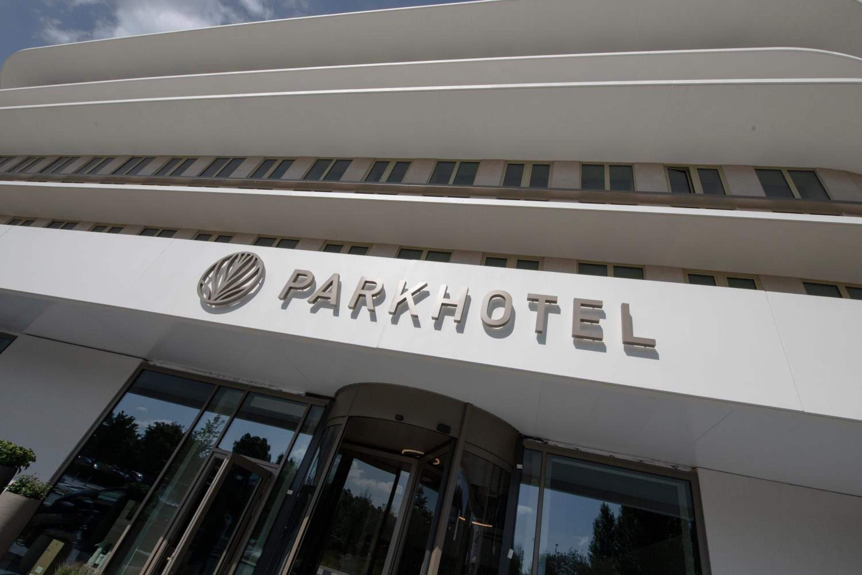 Un edificio moderno con un letrero que dice 'PARKHOTEL' sobre la entrada.