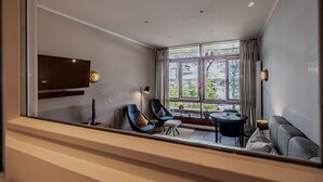 A modern living room with a large window, a flat-screen TV, and a sofa. - fewo1846 - Marina del Rey (App. 146) / Studio App. with sea view and beach chair (Glücksburg)