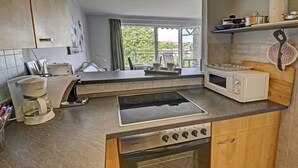 A modern kitchen with a built-in stove, oven, microwave, and a coffee maker.