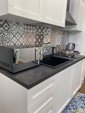 Kühlschrank, Mikrowelle, Herdplatte, Wasserkocher mit Kaffee-/Teezubehör