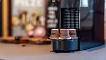 A coffee machine with four disposable cups labeled "biodegradable & compostable" on a table.
