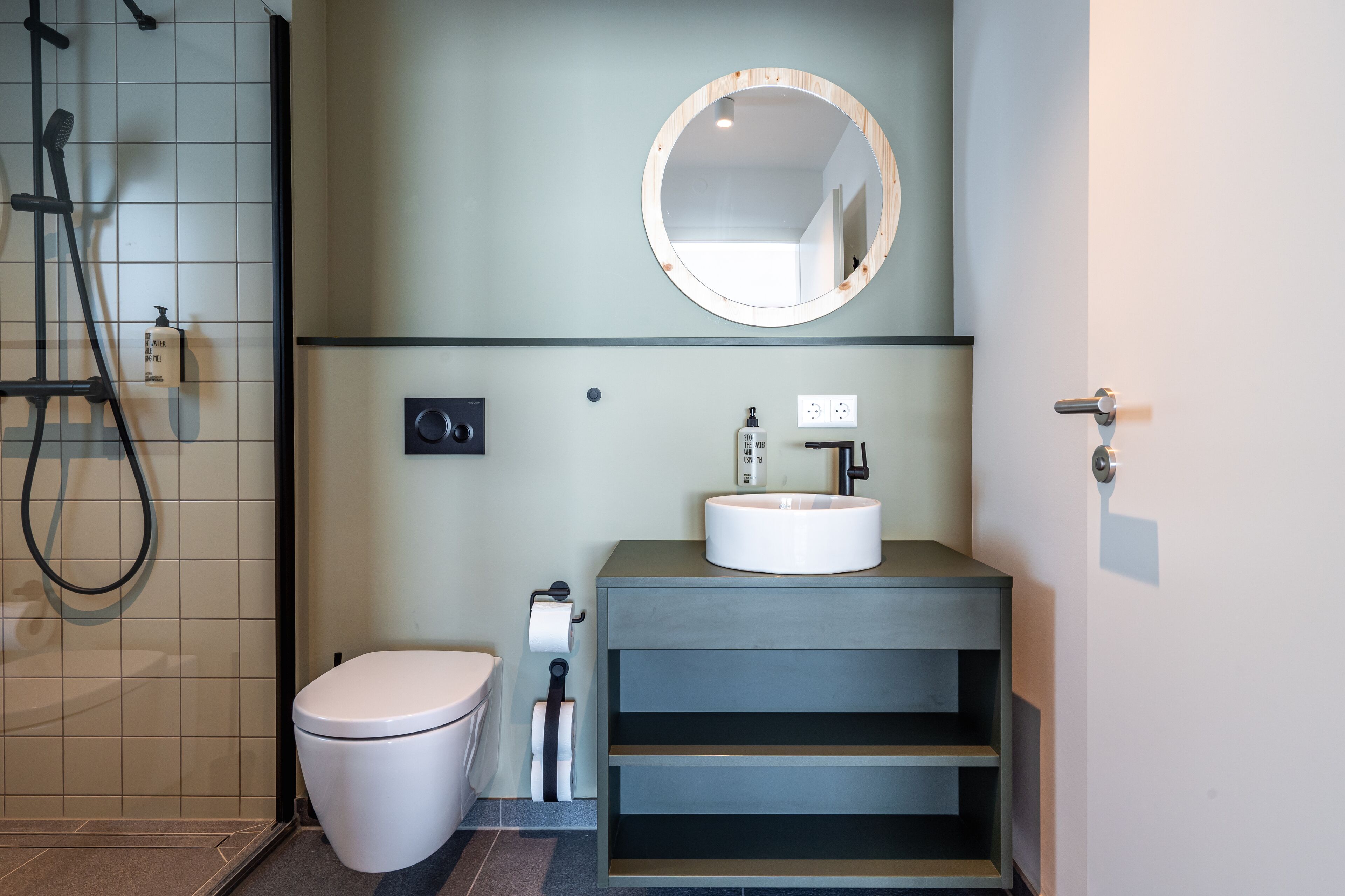 Ein modernes Badezimmer mit Toilette, Waschbecken und Dusche.