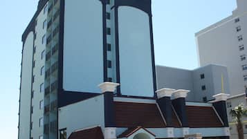 Um hotel com vários andares e design moderno, com uma entrada notável com área coberta e uma placa.