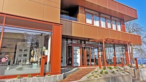 A modern building with a two-story structure, large glass windows, and a visible storefront with merchandise. - fewo1846 - Kajüte Fördeblick (App. 112) / family-friendly studio apartment (Glücksburg)