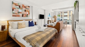 Een moderne hotelkamer met een groot bed, een bureau en uitzicht op de stad.