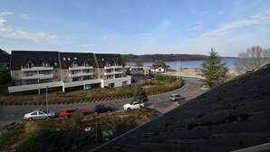 A residential area with a parking lot, a road, and a view of a body of water. - fewo1846 - Little Mermaid (App. 666) / studio apartment in the attic (Harrislee)