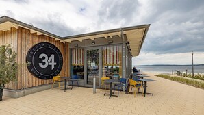 Ein Restaurant mit einer großen Beschilderung mit der Aufschrift "34" und Außenbereich mit Tischen und Stühlen.