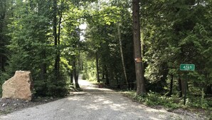 A gravel path in a forested area with a 'PRIVATE PROPERTY' sign and a street sign indicating 'ST 426.3'.