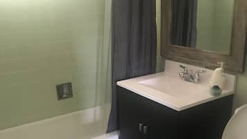 Bathtub, hair dryer, towels, shampoo