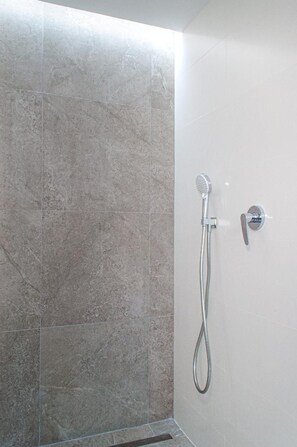 A shower area with a handheld showerhead and a wall-mounted control. - Modern & Centric One Bedroom Apartment in Alicante (Alacant/Alicante)