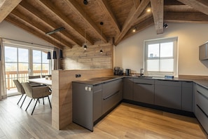 Enjoy a kitchen with a sink, dark cabinetry, and a wooden island, offering a view of the surrounding landscape.