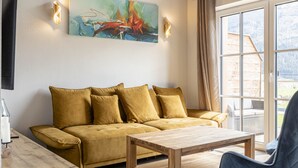 Un salon avec un canapé, une table basse en bois et un tableau accroché au mur.