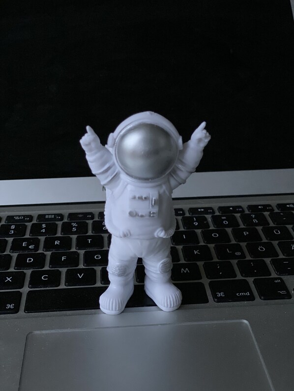 A white astronaut figurine standing on a laptop keyboard. - Space Night - Hostel (Berlin)