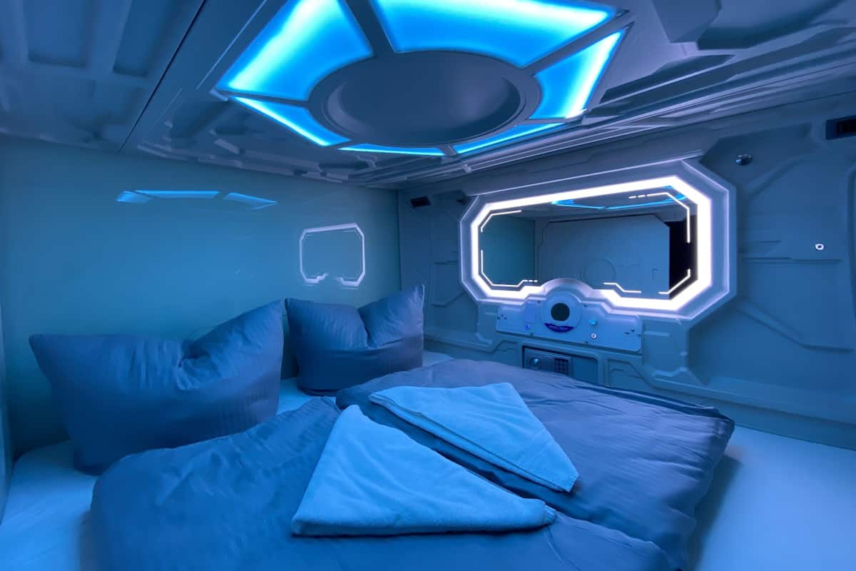 Una habitación futurista con una cama, almohadas y un panel de control.