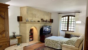 A living room with a fireplace, a television, a sofa, and a coffee table.