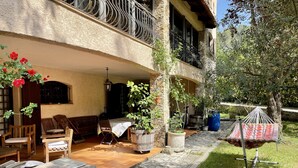 A patio area with outdoor seating, a hammock, and potted plants.