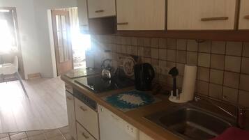 Eine Küche mit Geschirrspüler, Wasserkocher, Kaffeemaschine und Spüle.